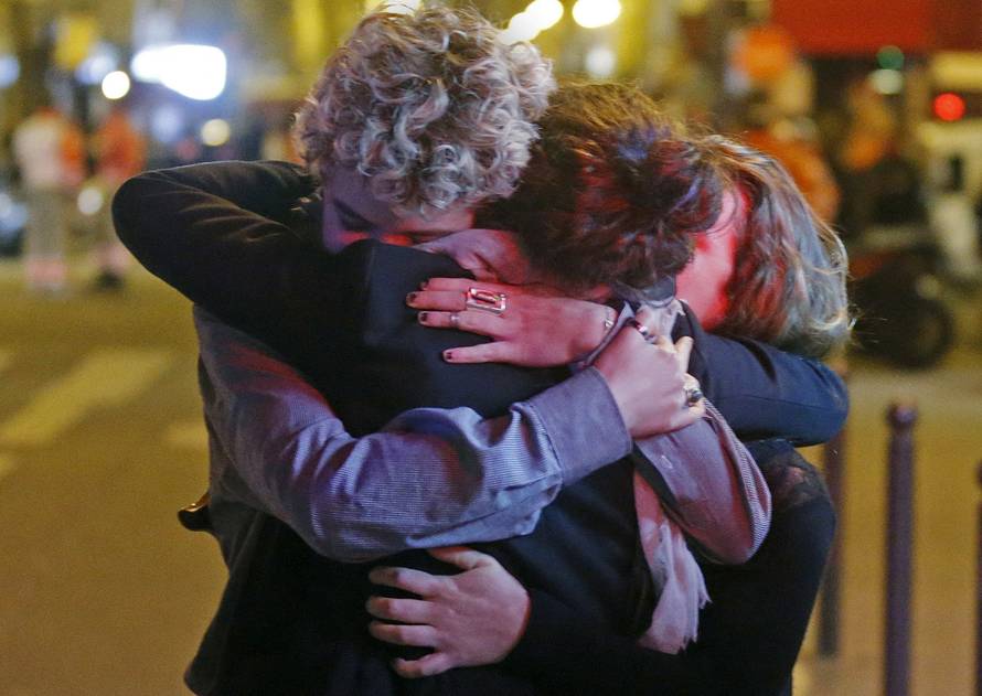 FILE PHOTO: People hug on the street near the Bataclan concert hall following fatal attacks in Paris, France,