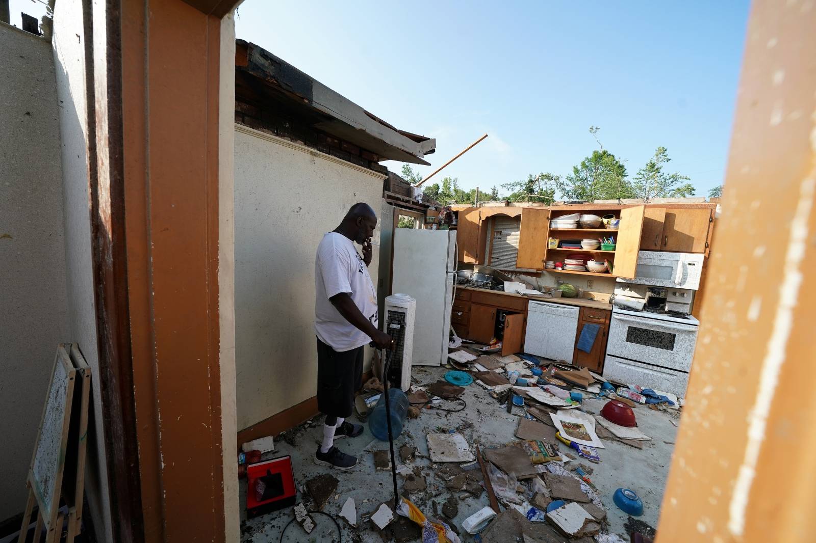 James Jackson, wearing an "In God We Trust" t-shirt smokes a cigarette in what is left of his home following a tornado in Jefferson City