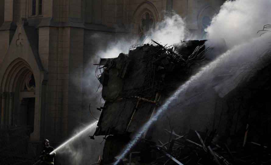 Firefighters try to extinguish the fire of a building that caught fire and collapsed in the center of Sao Paulo