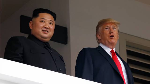U.S. President Donald Trump and North Korean leader Kim Jong Un react at the Capella Hotel on Sentosa island in Singapore