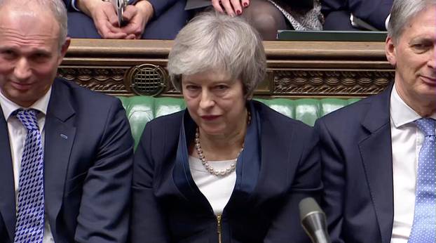 Prime Minister Theresa May sits down in Parliament after the vote on May