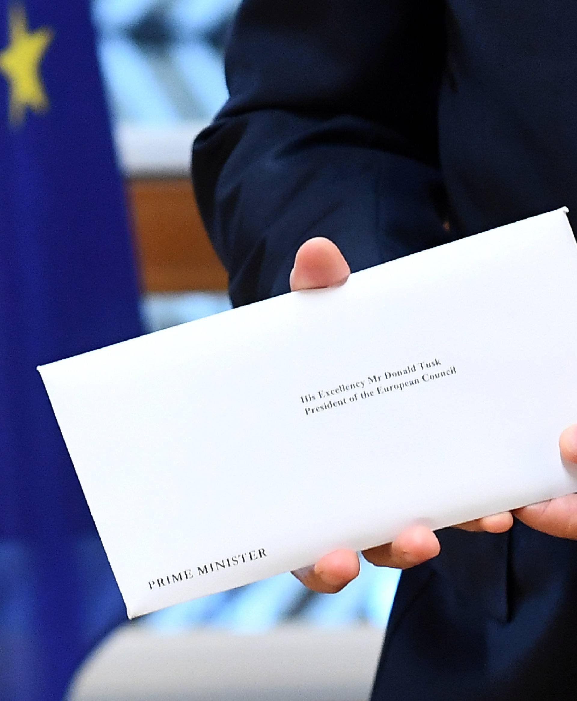 EU Council President Donald Tusk holds British Prime Minister Theresa May's Brexit letter which was delivered by Britain's permanent representative to the European Union, Barrow, that gives notice of the UK's intention to leave the bloc under Article 50