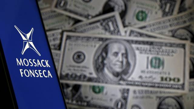 Picture illustration shows smartphone with Mossack Fonesca logo in front of a display of U.S. banknotes 