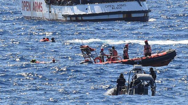 Migrants jump off the Spanish rescue ship Open Arms, close to the Italian shore in Lampedusa