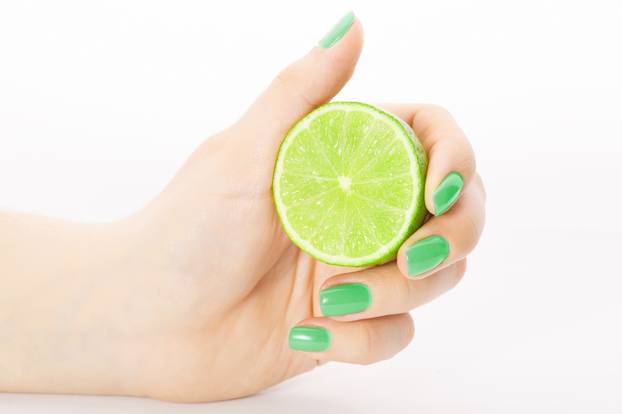 Fresh juicy tasty green lime in a Female hand