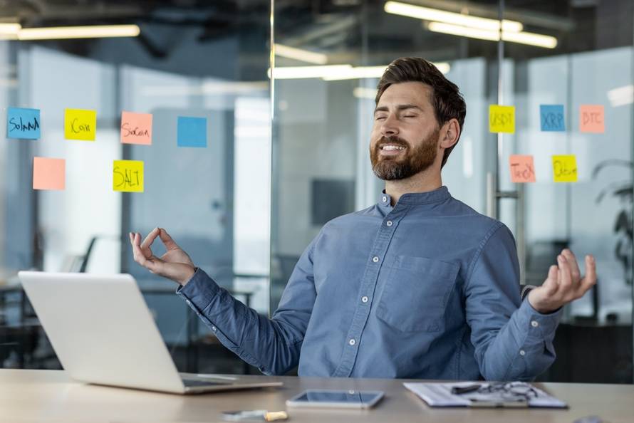 Businessman,Practicing,Mindfulness,Meditation,In,Modern,Office,Surrounded,By,Colorful