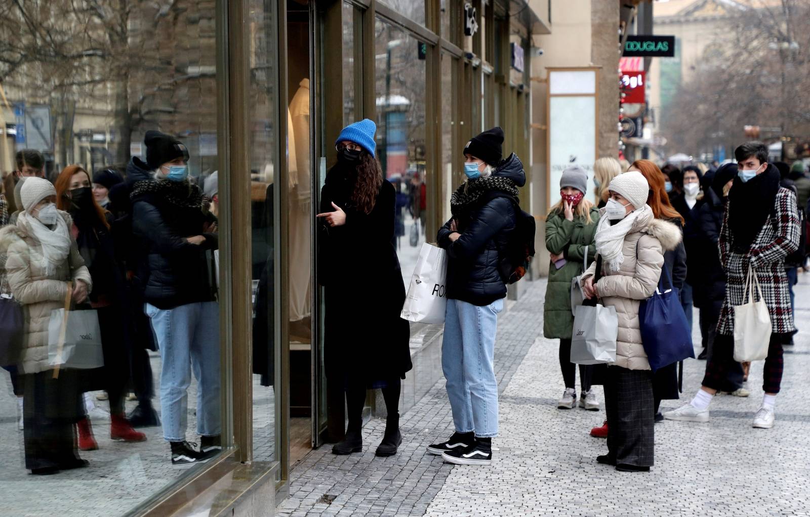 FILE PHOTO: Customers queue in front of a reopened shop during the coronavirus outbreak in Prague, Czech Republic