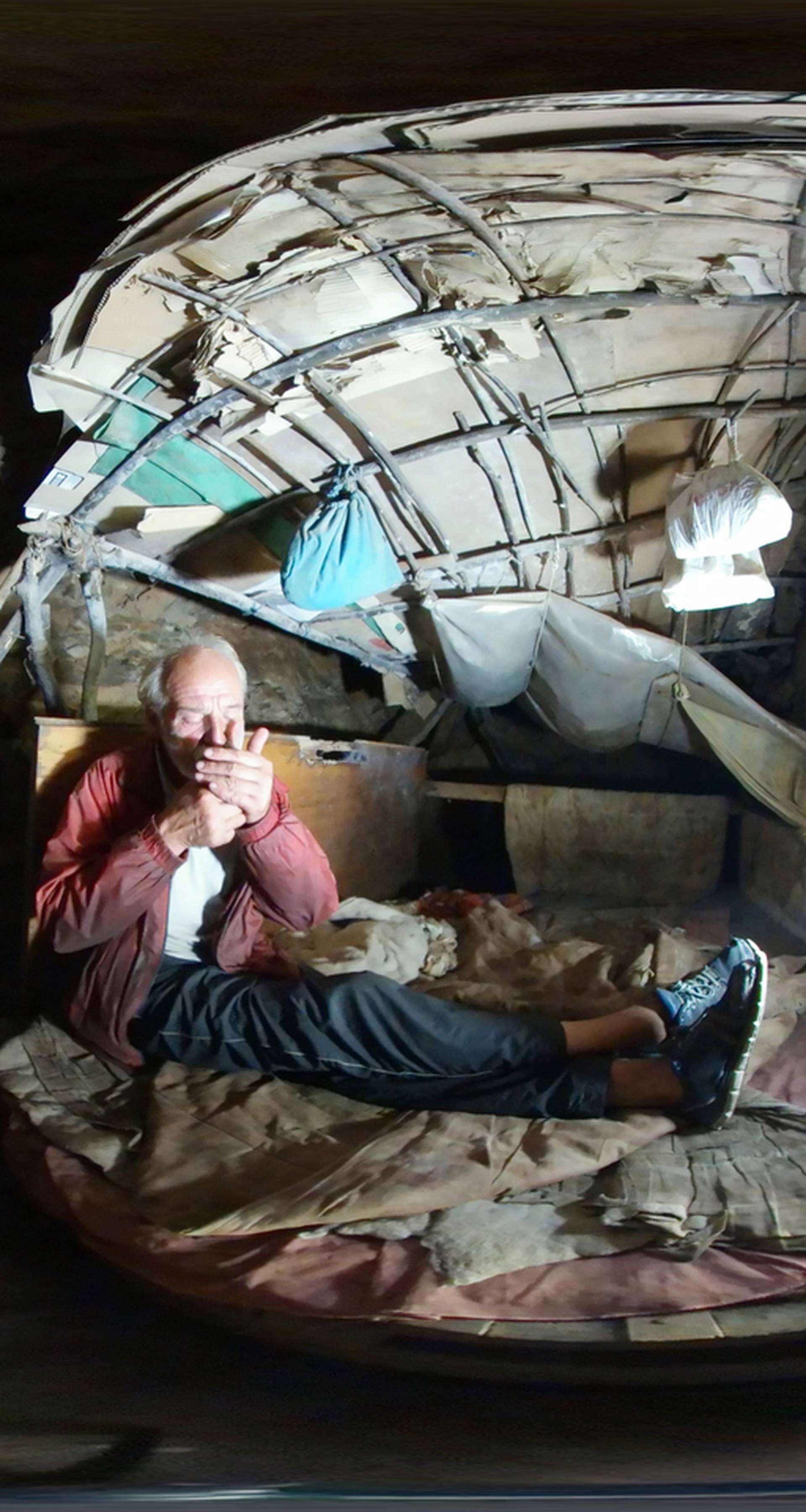 Former steel factory worker Zarko Hrgic lights a cigarette in his home, a cave near the central Bosnian city of Zenica