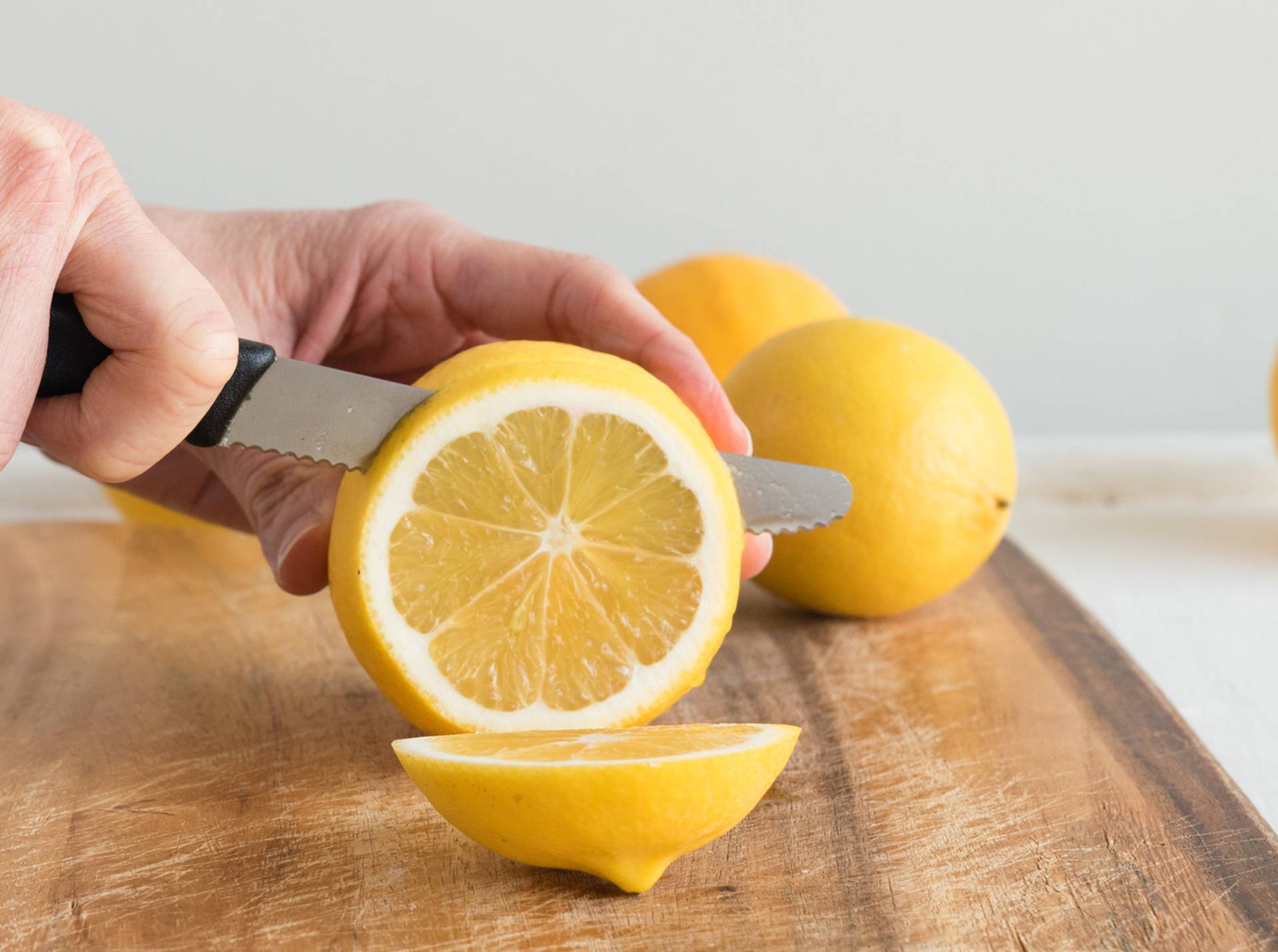 Middle aged woman's hands cutting lemons