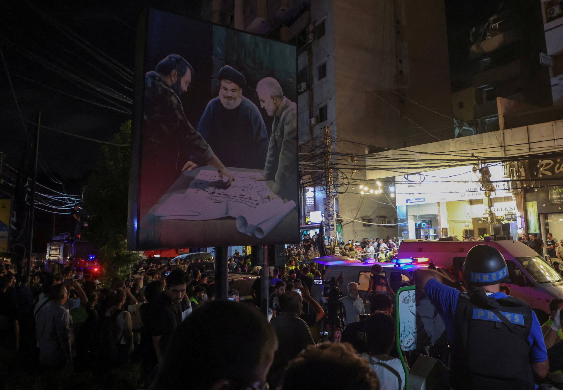 People gather near a damaged site after what security sources said was a strike on Beirut's southern suburbs