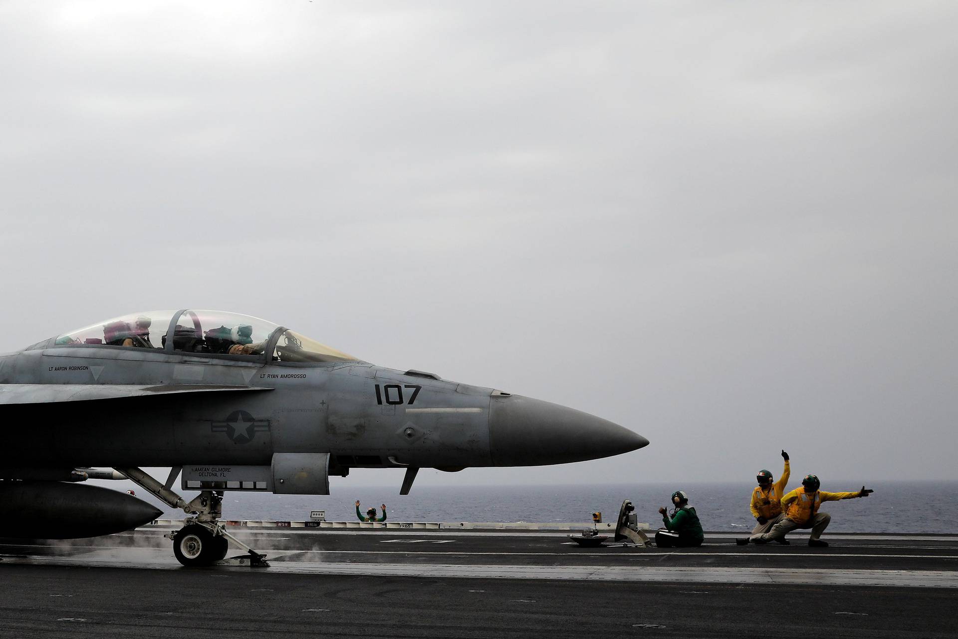 FILE PHOTO: U.S. Navy catapult officers signal to an F/A-18 fighter jet pilot for a safe take off, aboard the USS Harry S. Truman aircraft carrier in the eastern Mediterranean Sea