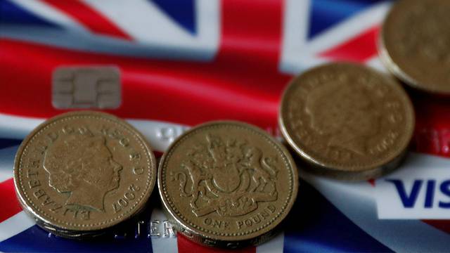 FILE PHOTO: British pound coins are seen on top of a Union Jack themed Visa credit card in this photo illustration taken in Manchester, Britain.