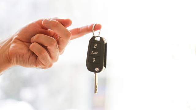 Hand,With,A,Car,Key.,Isolated,On,White,Background.