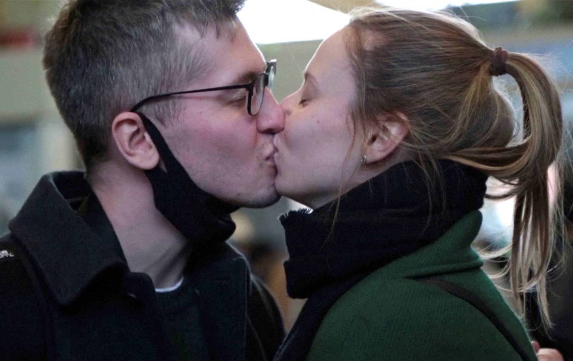 Russian software engineer Mikhail Liublin kisses his Ukrainian girlfriend at a train station in Zahony