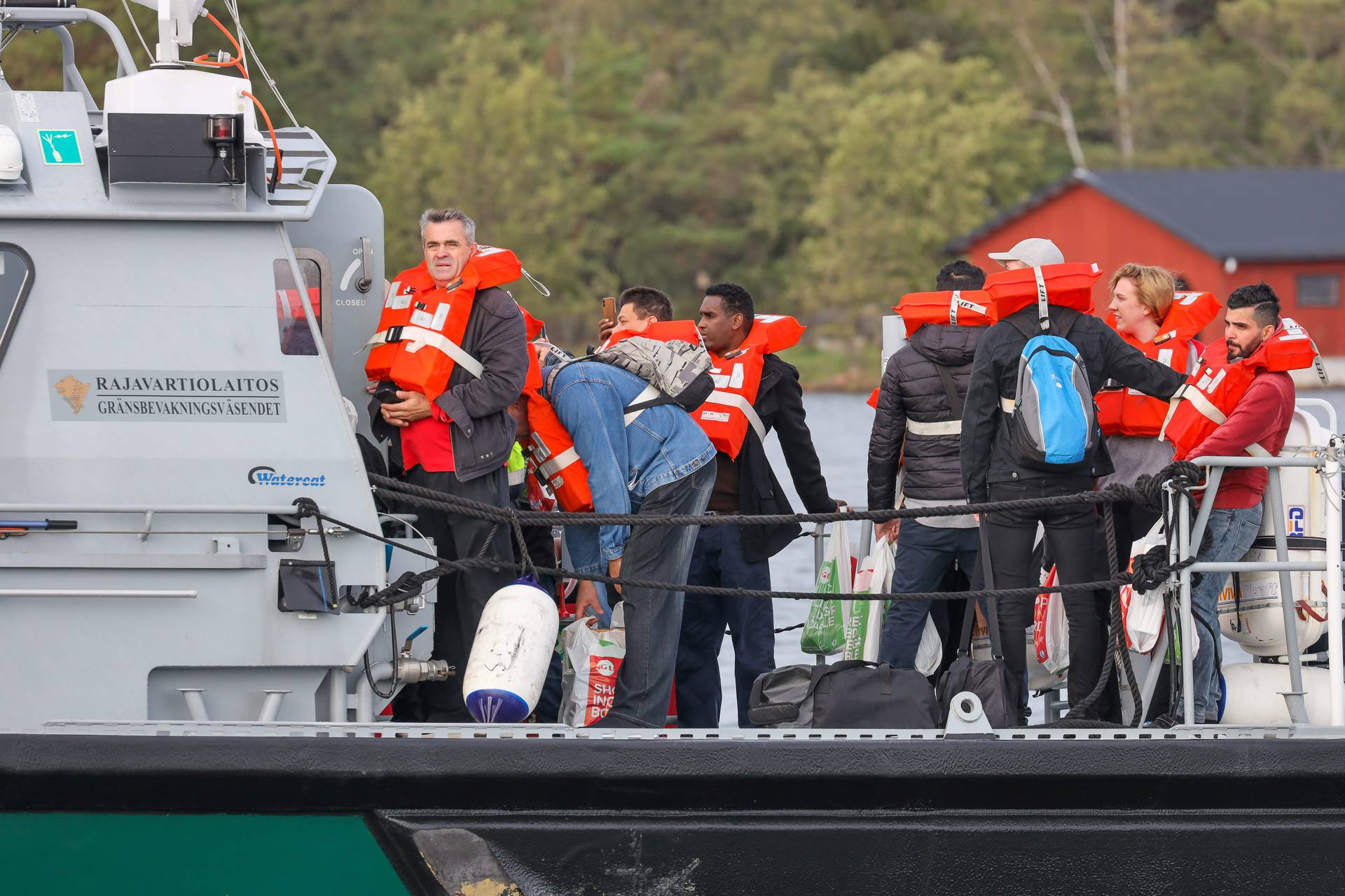 People evacuated from Viking Line's cruiseferry MS Amorella disembark from the Finnish Border Guard's vessel, in Svino
