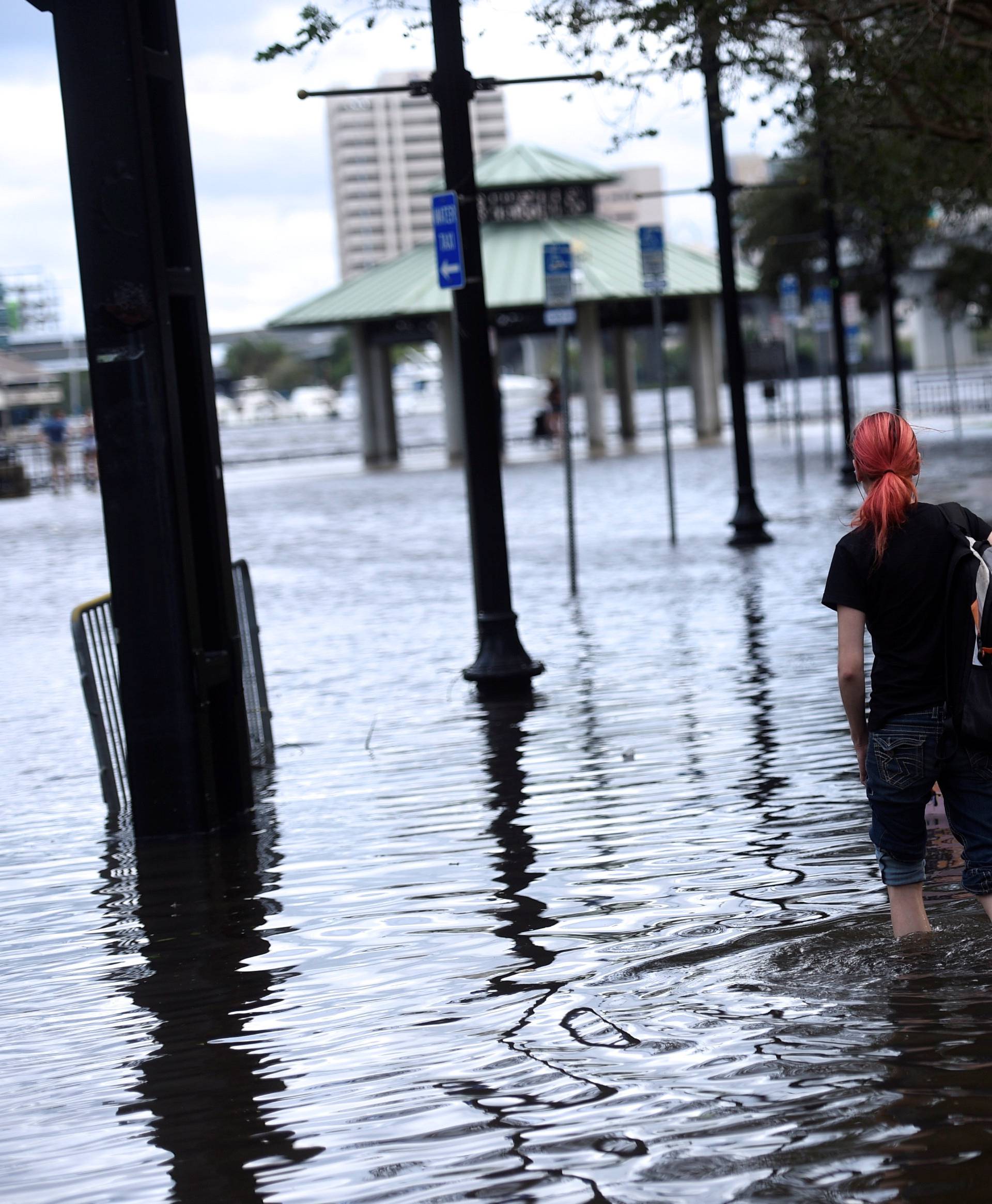 A woman walks barefoot through floodwaters after Hurricane Irma