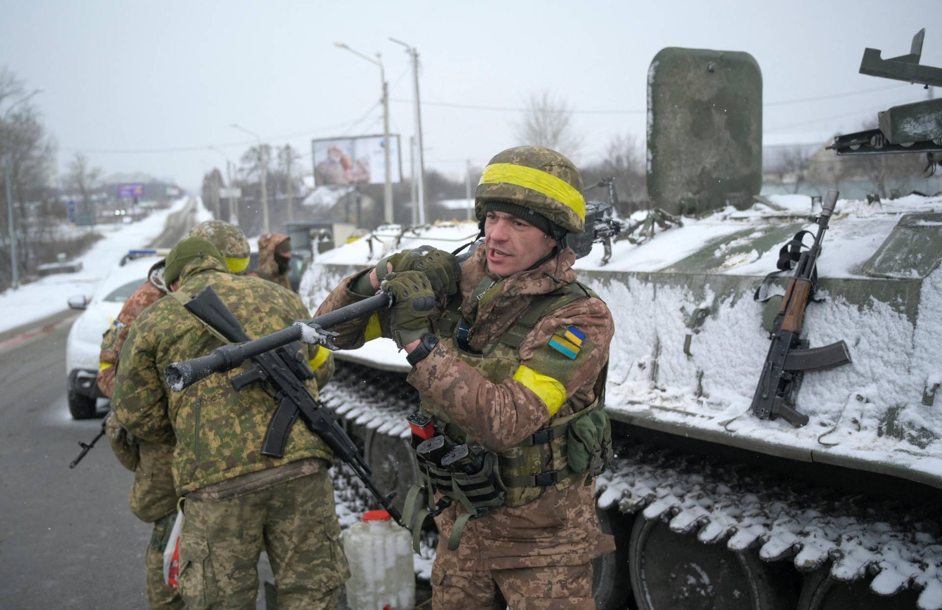 Ukrainian servicemen stand guard on a road in Kharkiv