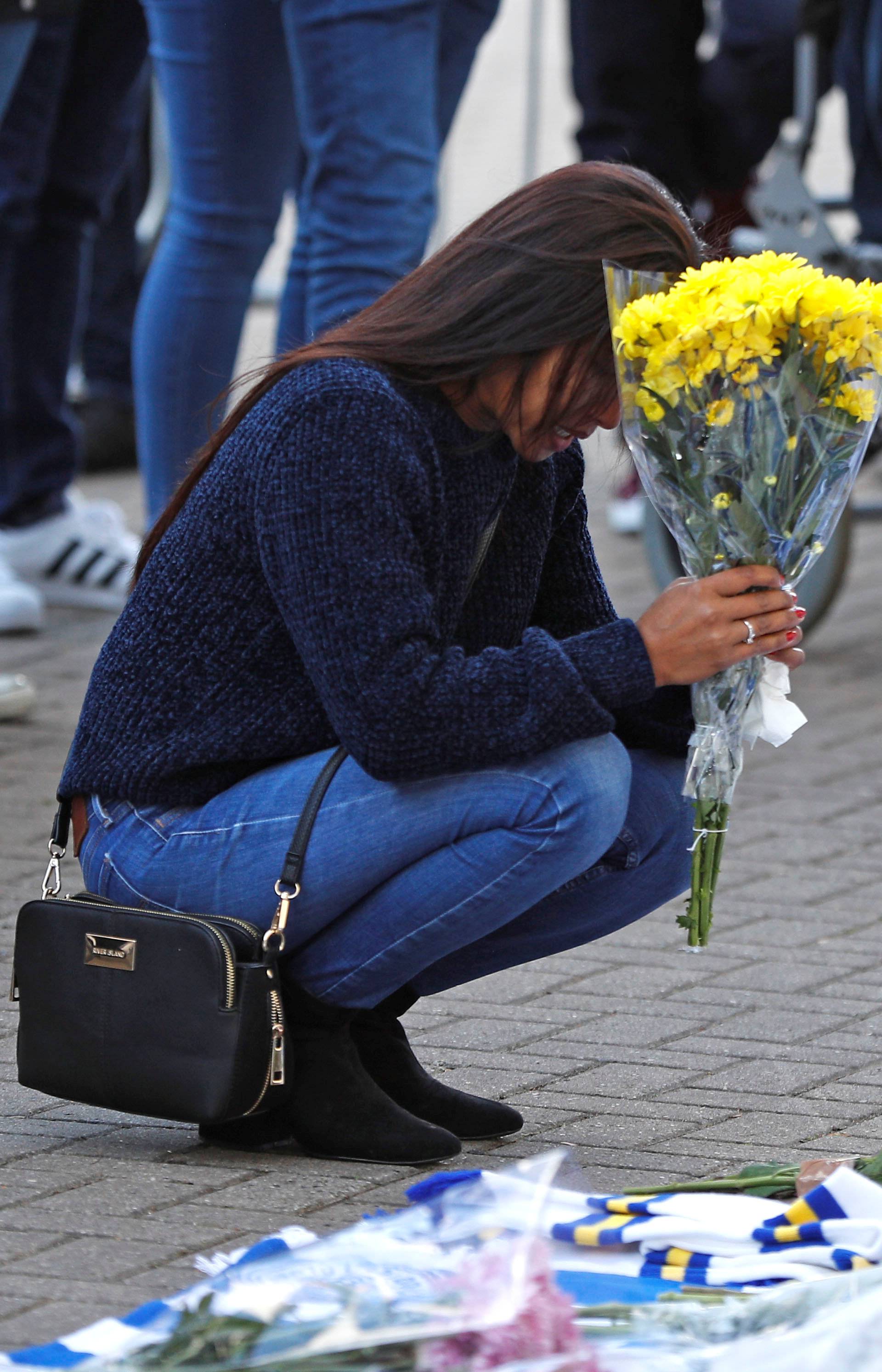 Leicester City football fans pay their respects outside the football stadium, after the helicopter of the club owner Thai businessman Vichai Srivaddhanaprabha crashed when leaving the ground on Saturday evening after the match, in Leicester