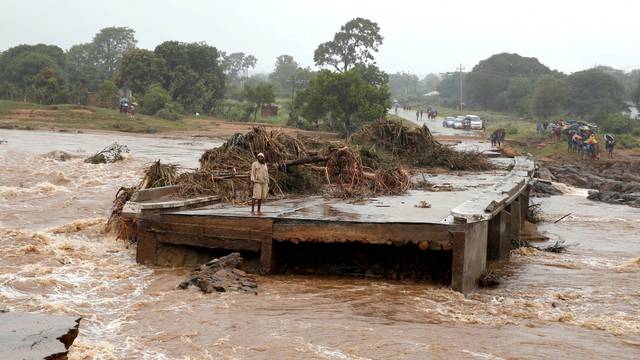 A man looks at a washed away bridge along Umvumvu river following Cyclone Idai in Chimanimani