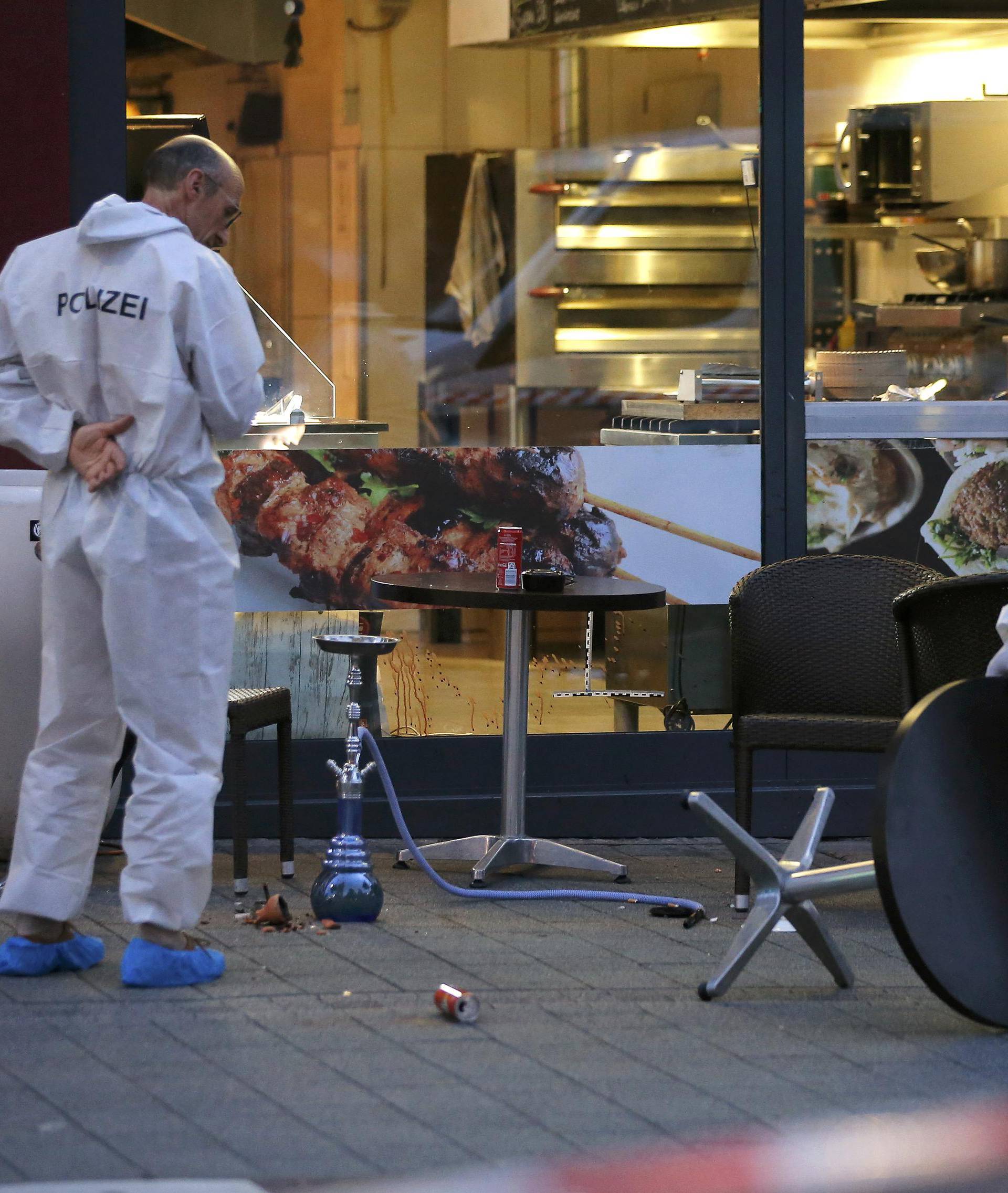 Police forensic experts work outside where a 21-year-old Syrian refugee killed a woman with a machete in Reutlingen