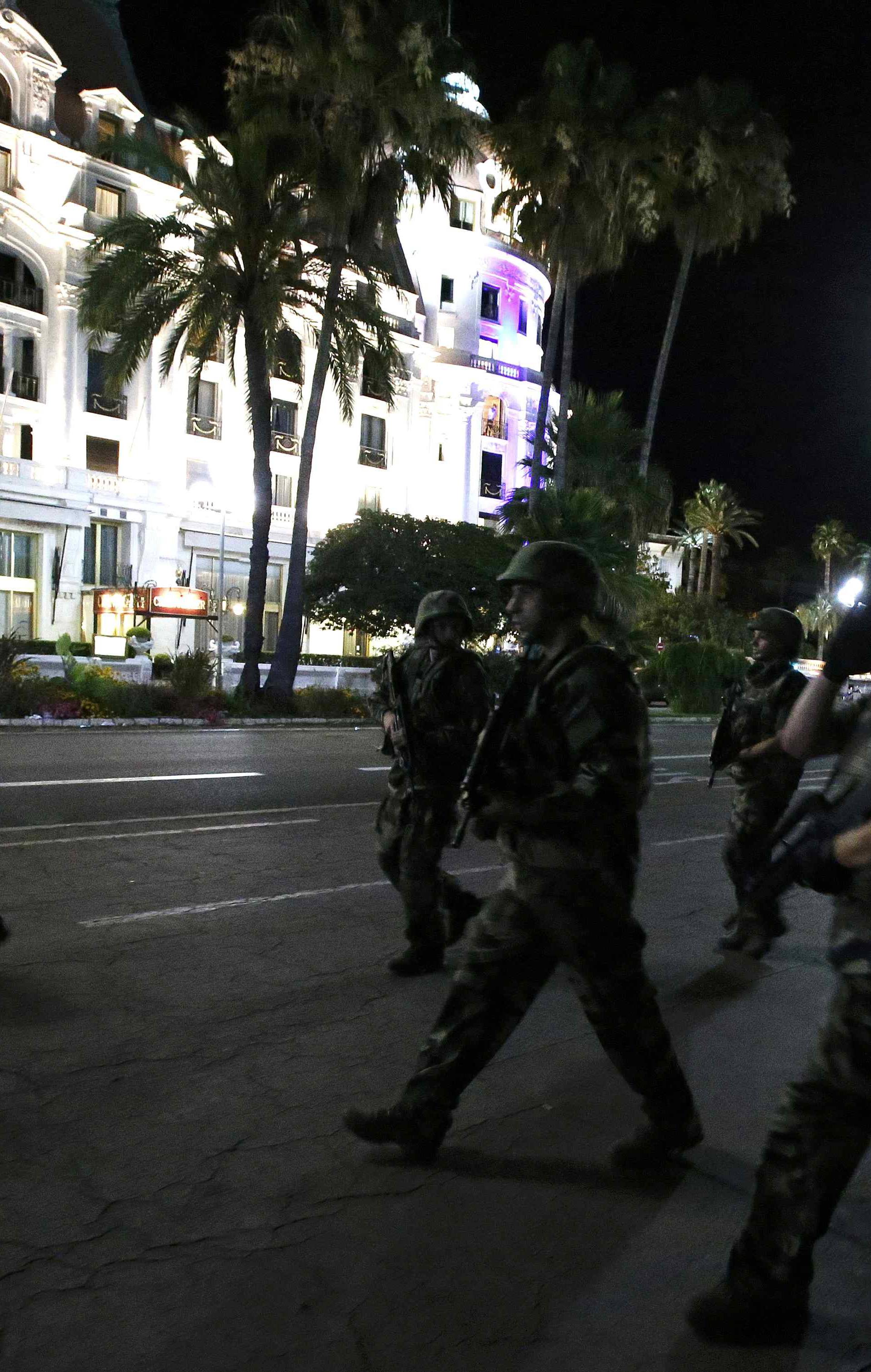 French soldiers advance on the street after at least 30 people were killed in Nice, France, when a truck ran into a crowd celebrating the Bastille Day national holiday