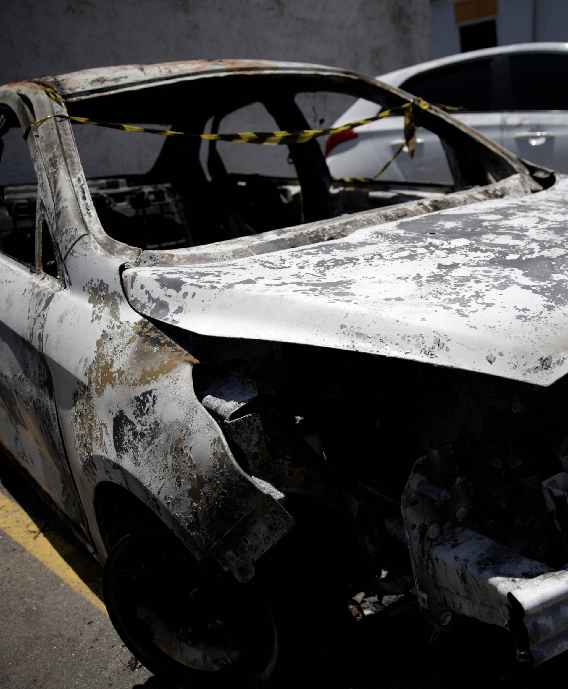 A burned car in which a body was found during searches for the Greek Ambassador for Brazil Kyriakos Amiridis, is pictured at a police station in Belford Roxo