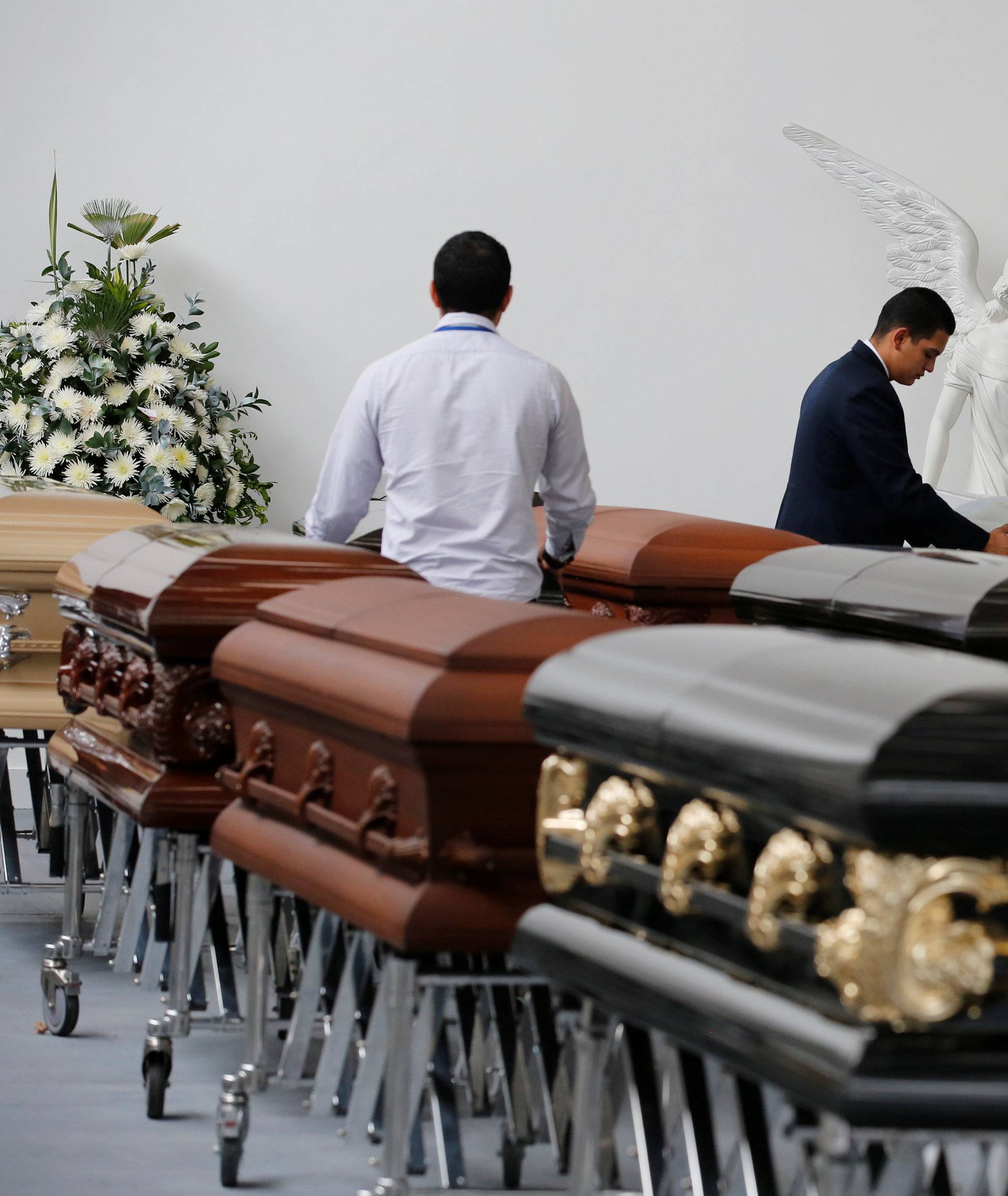 Funeral workers arrange coffins holding the remains of the victims who died in an accident of a plane that crashed into the Colombian jungle with Brazilian soccer team Chapecoense onboard, in Medellin