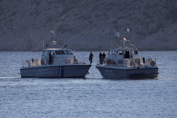 Coastguard boats inspect the area where four people, including a nine-year-old girl, died and at least five were injured after a boat with about 20 people on board collided with a speedboat off the Greek holiday island of Aegina close to Athens