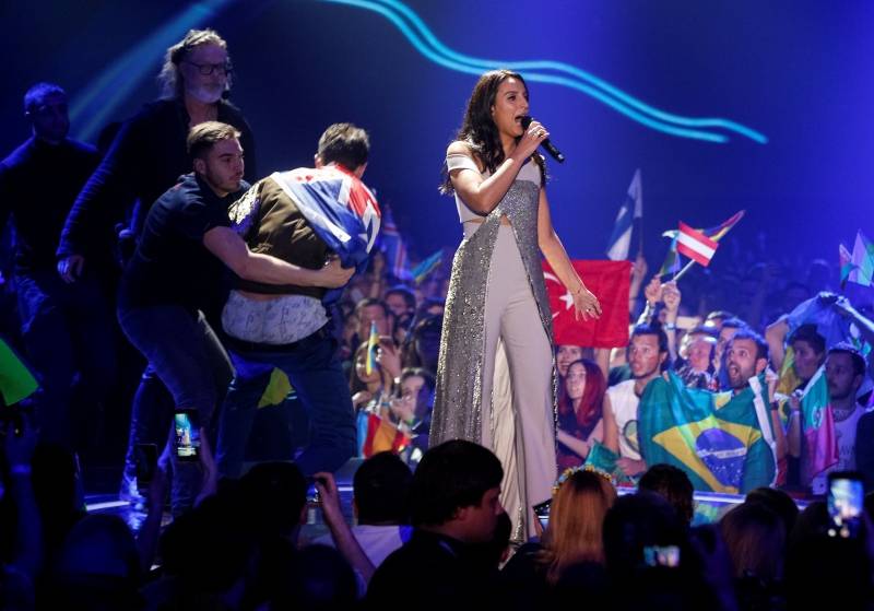 Ukraine's Jamala performs a song as security detain a fan during the grand final of the Eurovision Song Contest 2017 at the International Exhibition Centre in Kiev