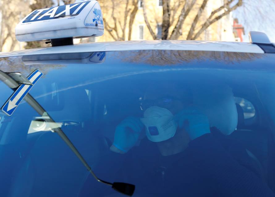 Seminario, a taxi driver in Milan, wears a protective mask