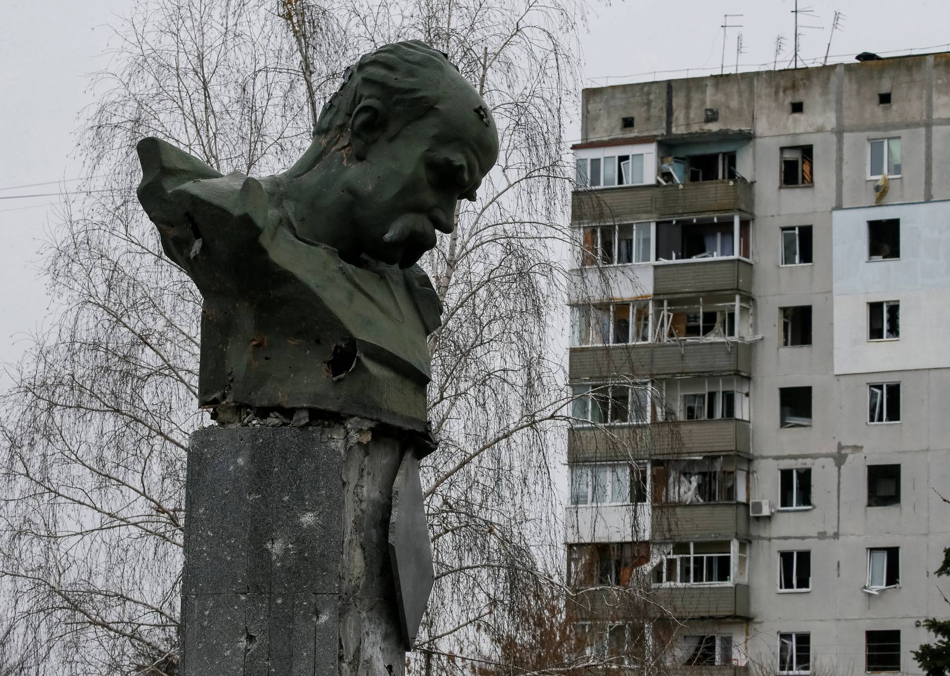 The monument of Ukrainian poet Taras Shevchenko with traces of shelling is seen near a destroyed house in Borodyanka