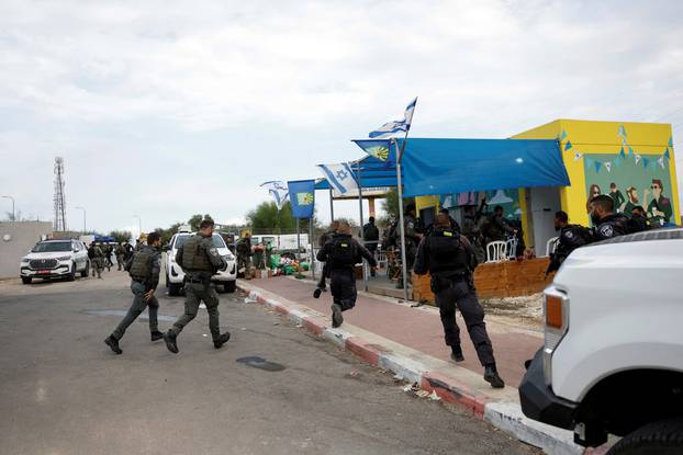 Israeli police and border police run to a bomb shelter while sirens sound as rockets from Gaza are launched towards Israel, near Sderot, southern Israel