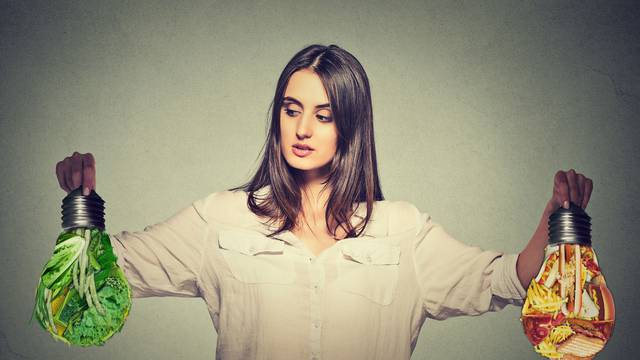 Woman thinking making diet choices junk food or green vegetables