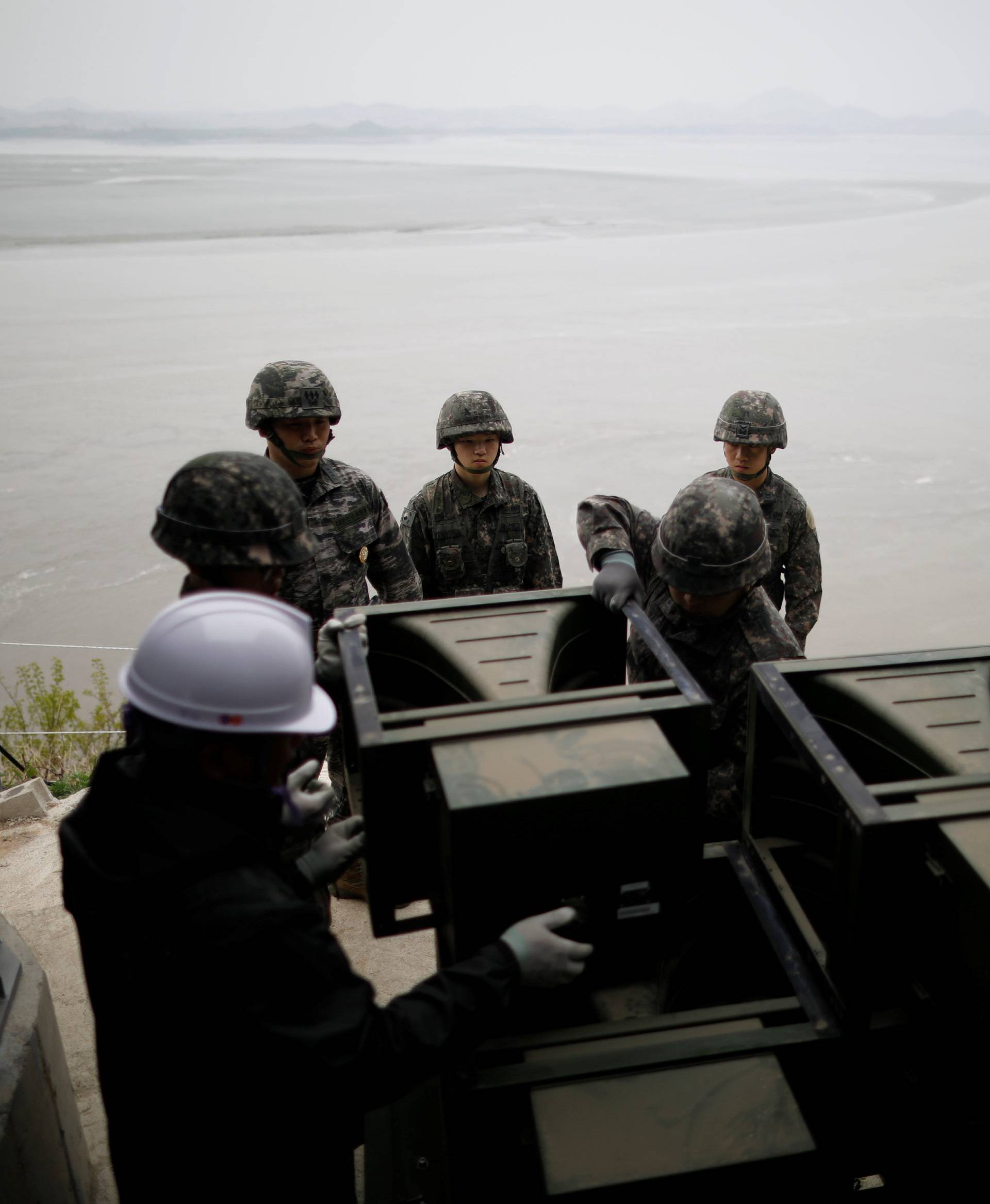 South Korean soldiers dismantle loudspeakers that were set up for propaganda broadcasts near the demilitarized zone separating the two Koreas in Paju