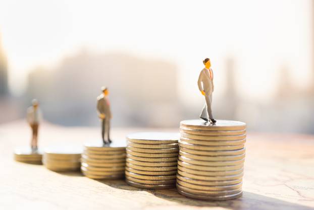 Miniature,People:,Small,Figure,Standing,On,Stack,Of,Coin.,Money