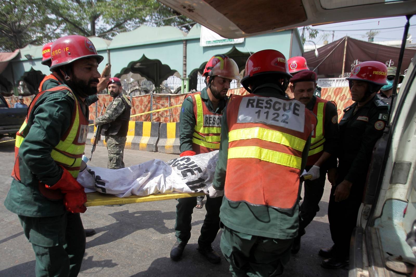Rescue workers move a body in an ambulance from the site of a blast in Lahore