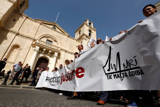 Demonstrators carry a banner during a protest against government corruption in light of the revelations in the Daphne Project, in Valletta