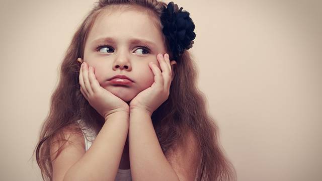 Beautiful child girl looking sad with pouted lips. Closeup