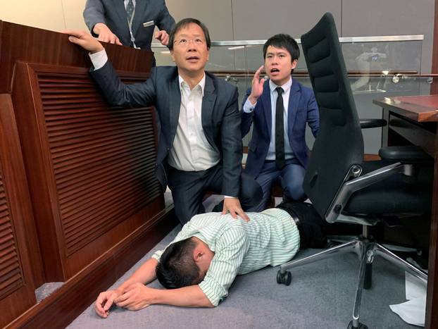 Pro-democracy lawmaker Gary Fan lies down after clashes with pro-Beijing lawmakers during a meeting for control of a meeting room to consider the controversial extradition bill, in Hong Kong