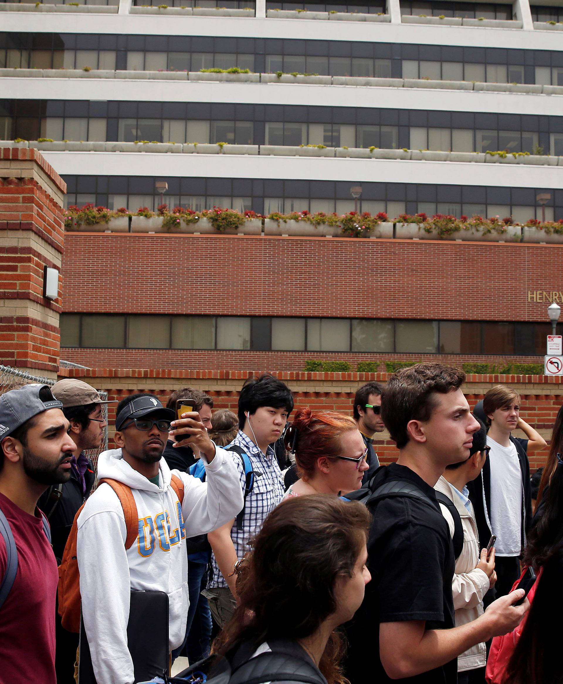 Students leave campus after police officers conducted a search at the University of California, Los Angeles (UCLA) campus after it was placed on lockdown following reports of a shooter that left 2 people dead in Los Angeles