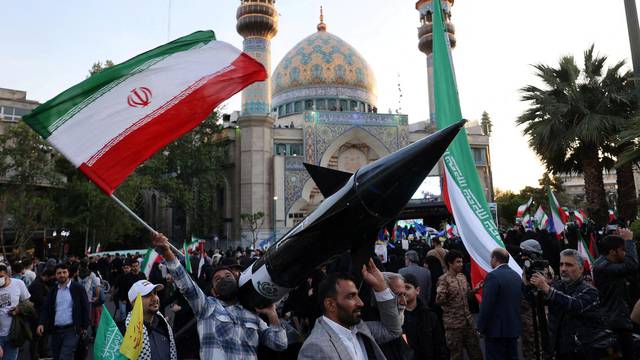 FILE PHOTO: Iranians carry a model of a missile during a celebration following the IRGC attack on Israel, in Tehran