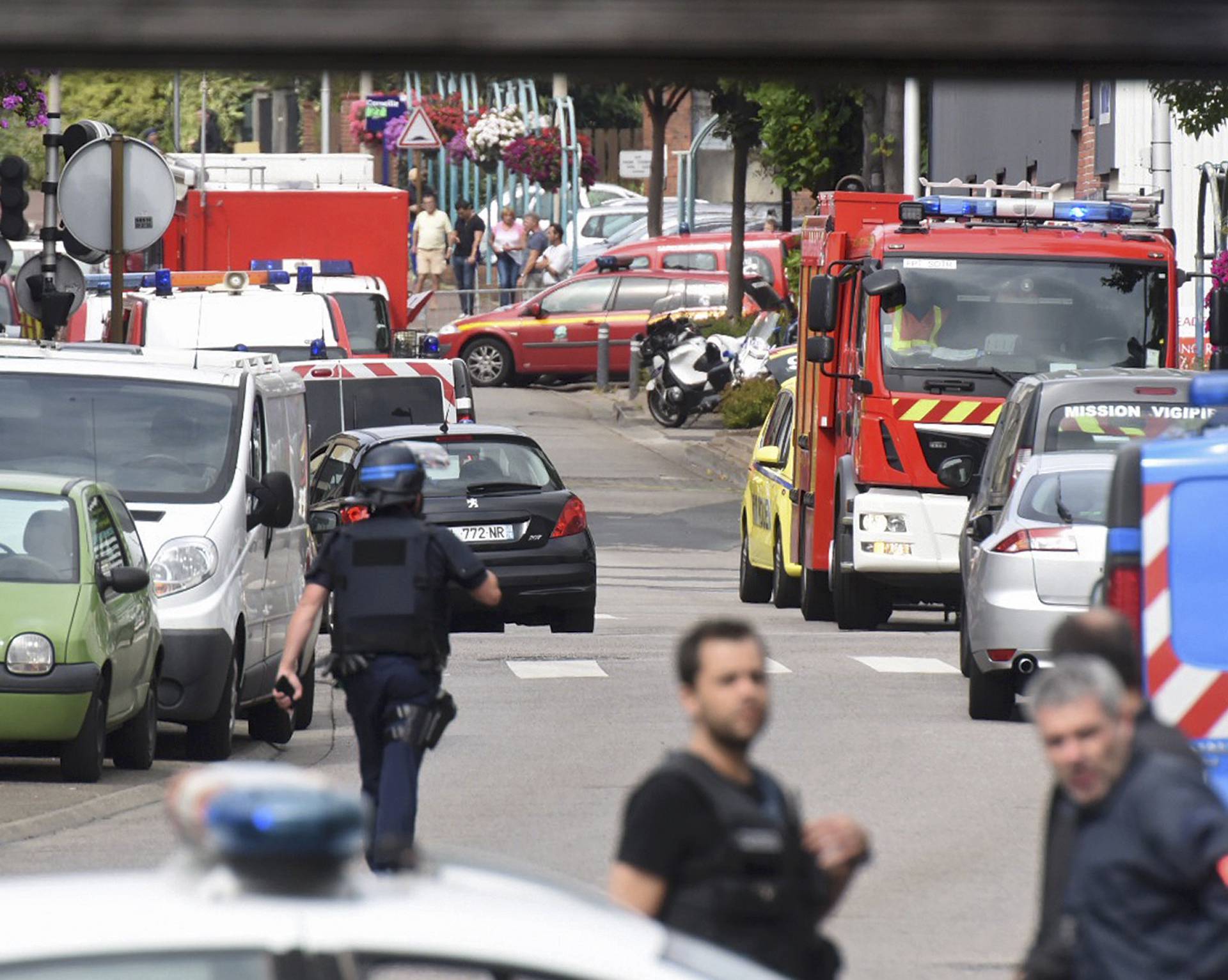 Police and rescue workers stand at the scene after two assailants had taken five people hostage in the church at Saint-Etienne-du -Rouvray near Rouen in Normandy