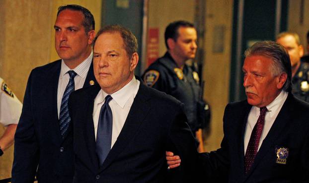 Film producer Harvey Weinstein is led handcuffed by police into his hearing at Manhattan Criminal Court