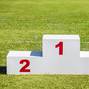 White wooden winner podium placed on green grass sport field on 