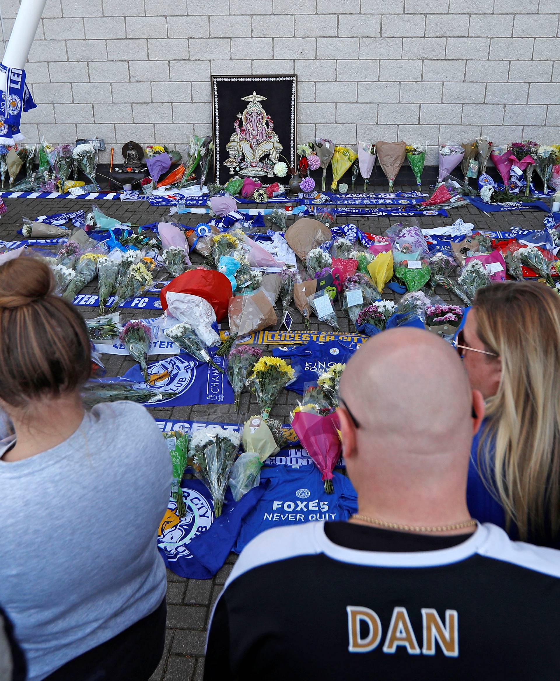 Leicester City football fans pay their respects outside the football stadium, after the helicopter of the club owner Thai businessman Vichai Srivaddhanaprabha crashed when leaving the ground on Saturday evening after the match, in Leicester