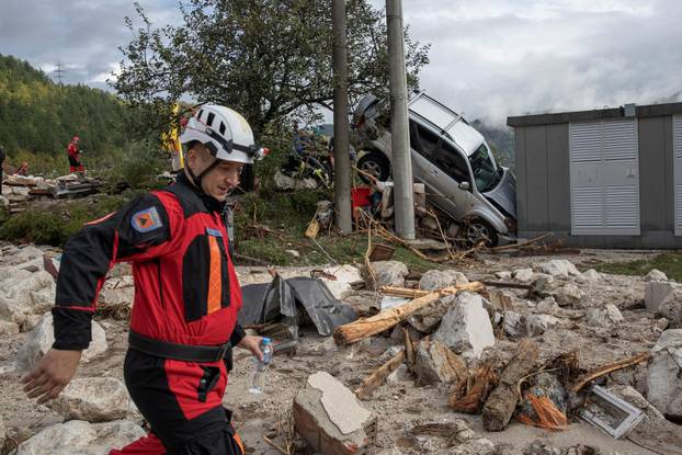 A rescue worker walks along debris following a landslide in the flooded village of Donja Jablanica