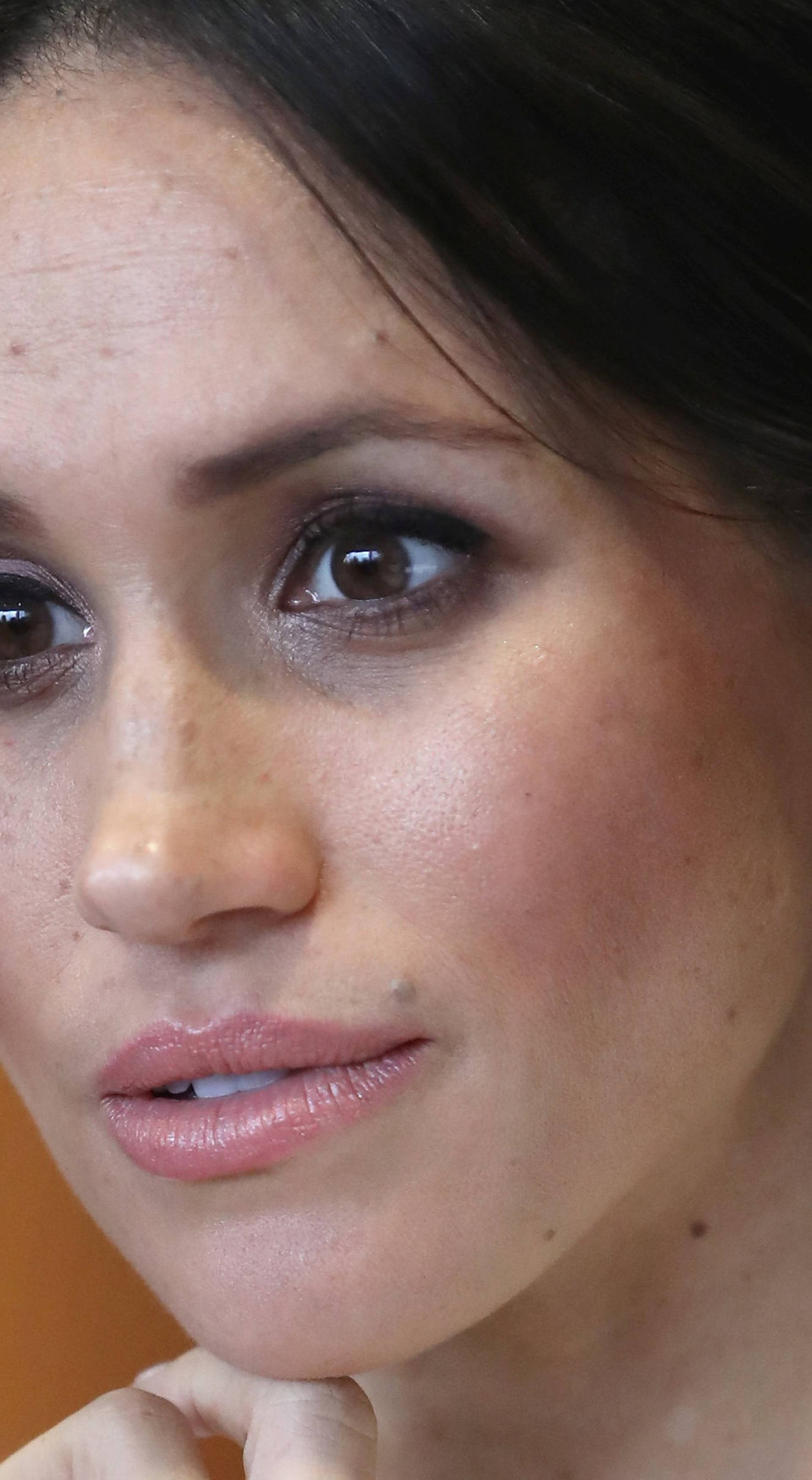 The fiancee of Britain's Prince Harry, Meghan Markle, reacts during a visit to a science park called Catalyst Inc., in Belfast