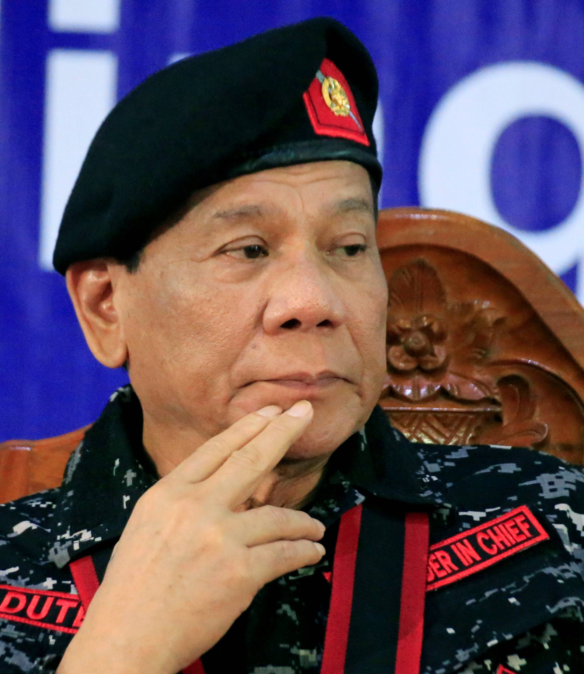 Philippine President Rodrigo Duterte, wearing a military uniform, gestures as he attends the 67th founding anniversary of the First Scout Ranger regiment in San Miguel town, Bulacan province, north of Manila