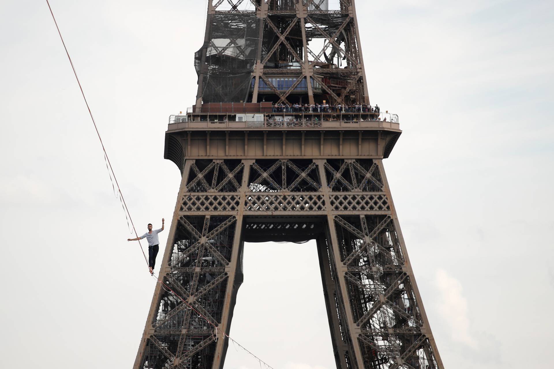 French acrobat Nathan Paulin walks on a slackline between the Eiffel Tower and the Theatre National de Chaillot as part of events around France for National Heritage Day