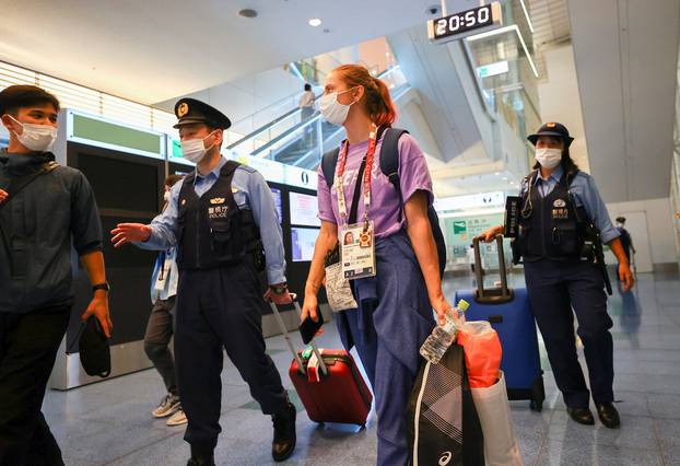 Belarusian athlete Krystsina Tsimanouskaya is escorted by police officers at Haneda international airport in Tokyo, Japan